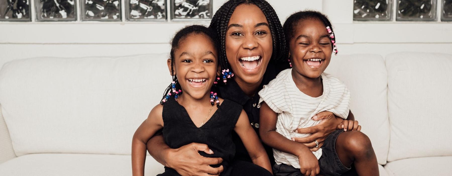 a woman sitting on a couch with two kids