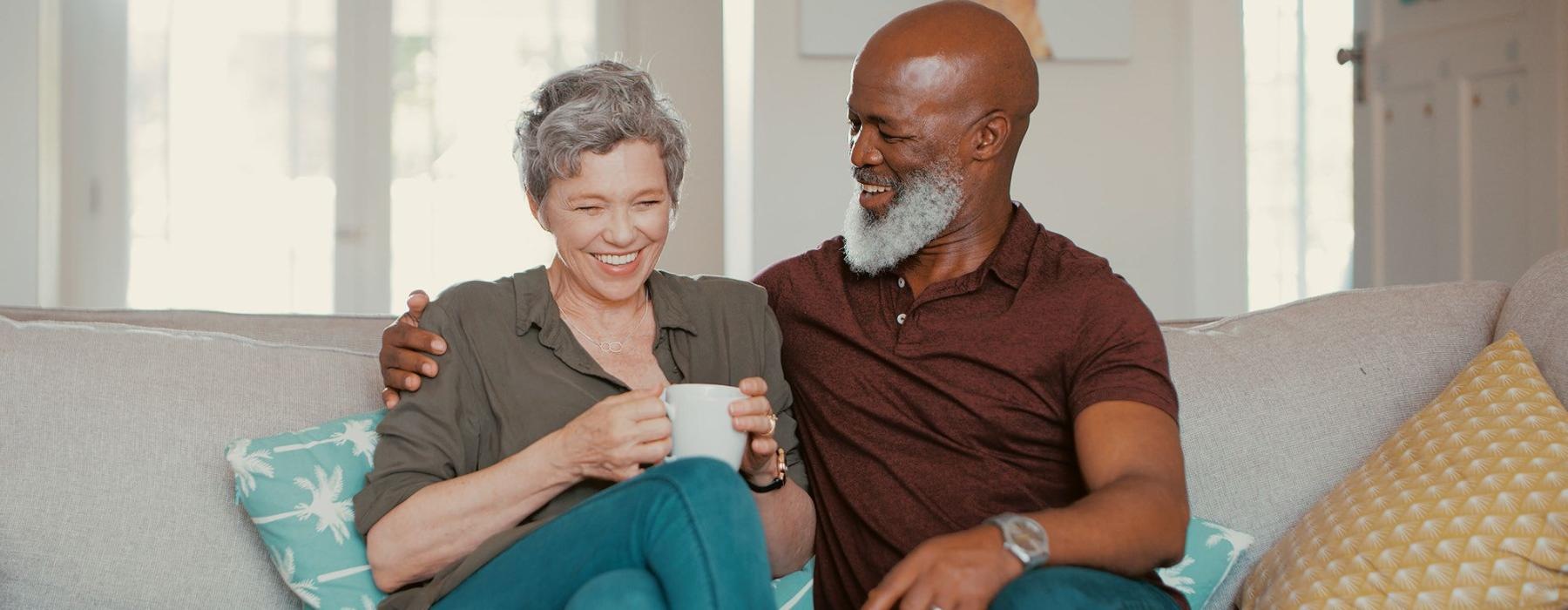 smiling, older couple, sit together on a couch