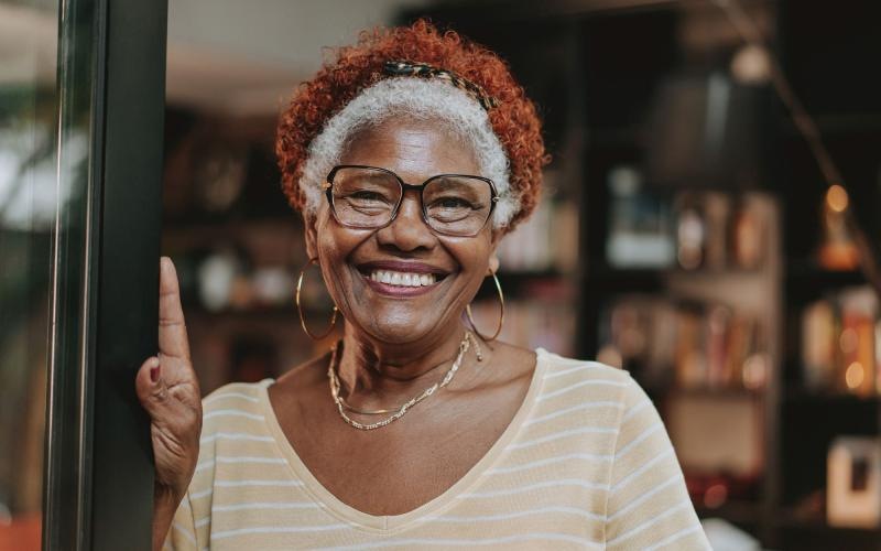 a woman wearing glasses and smiling